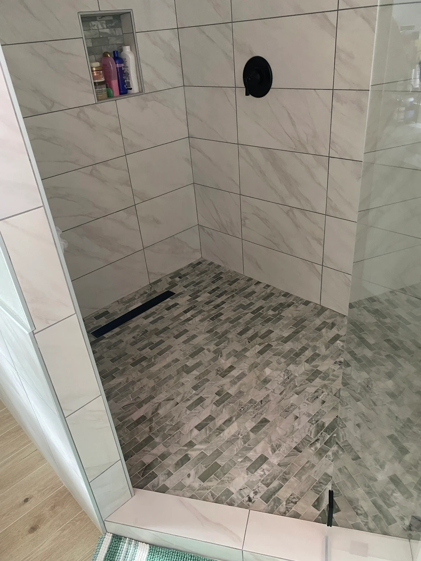 Walk-in shower with mosaic tile floor