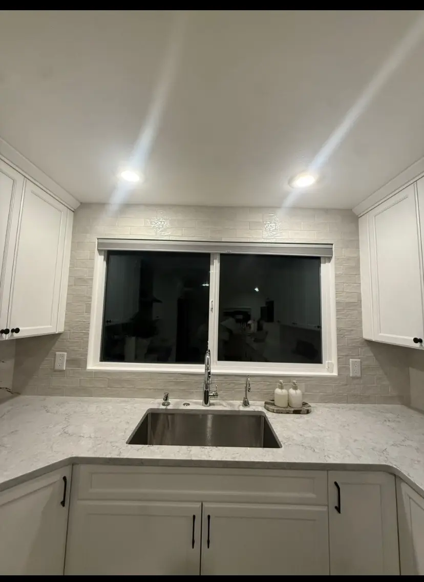 Bright kitchen with white cabinetry and sink